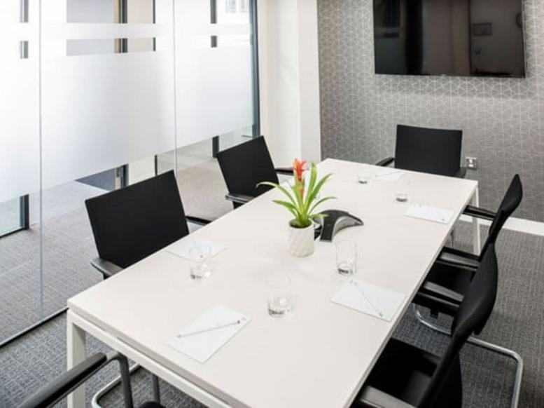 Meeting room with a white table, black chairs, and a potted plant at 88-94 Wentworth Street, Universal House.