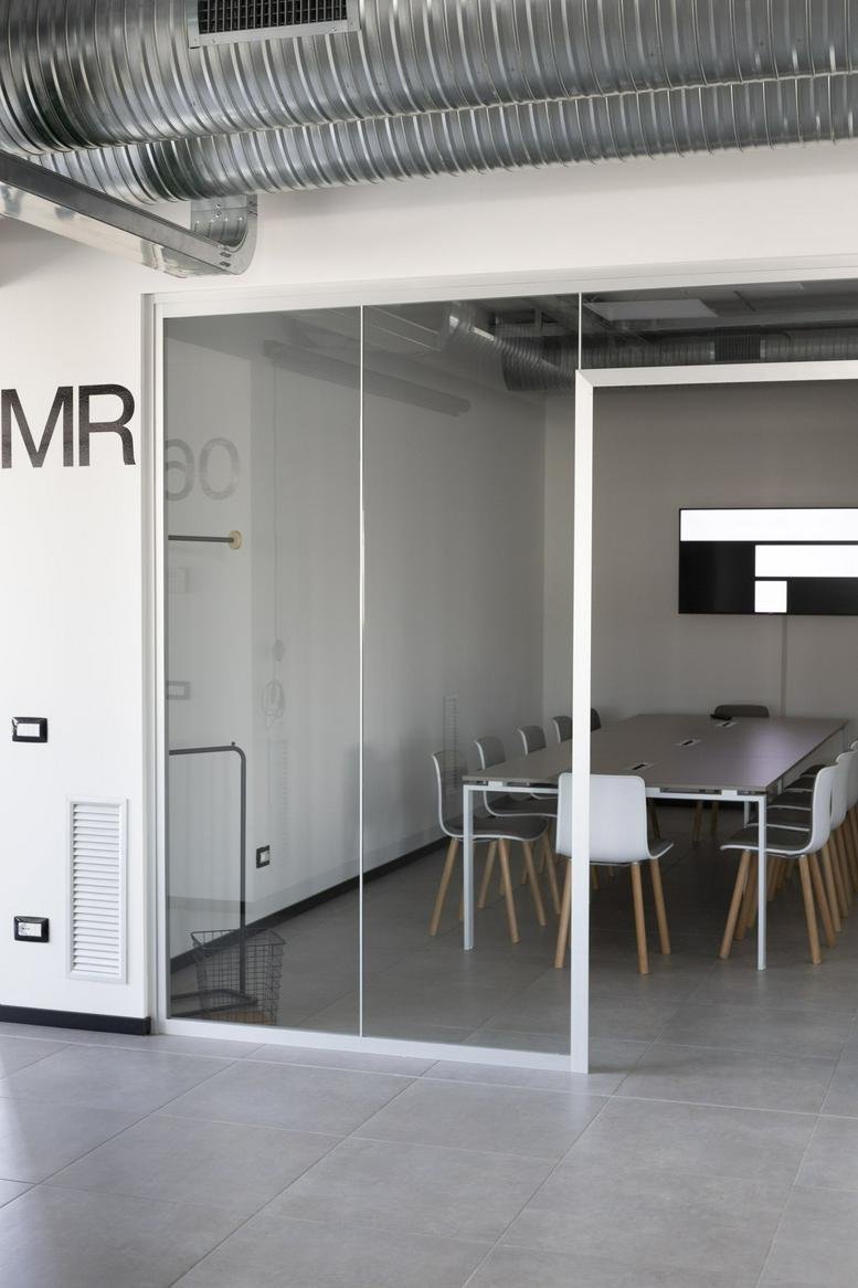 Meeting room with glass walls and large table at 93, Via Nazionale.