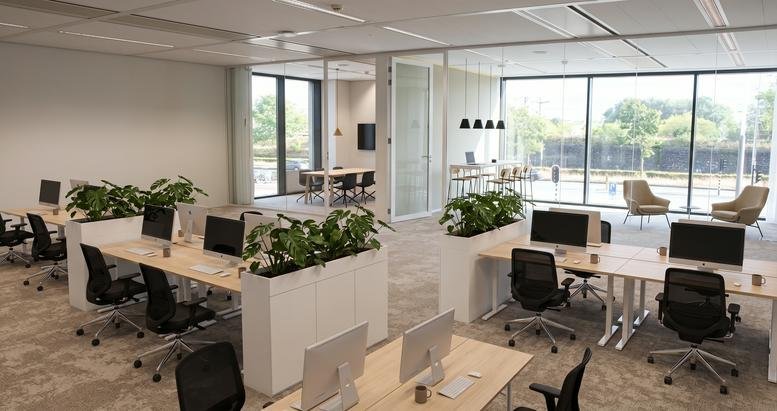 Spacious open-plan workspace at 99, Piet Heinkade with desk clusters and integrated greenery.