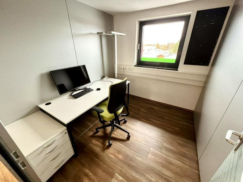 Bright private office at Alpina-Ring 9 with a white corner desk and ergonomic chair.