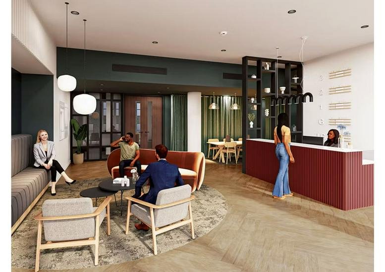 Spacious reception lobby at Ambika House, 9-11 Portland Place with a red front desk and lounge seating.