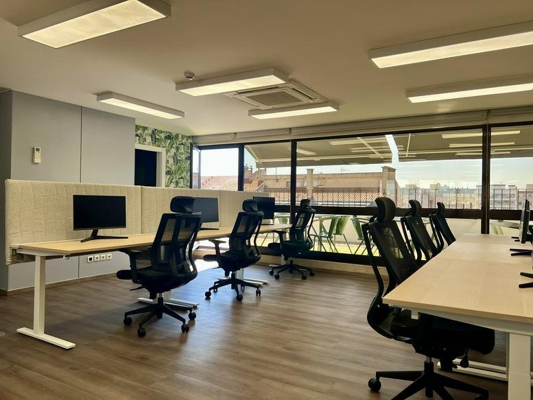 Spacious open-plan workspace at Avenida Defensores de Chaves 52,7 with large windows and city views.