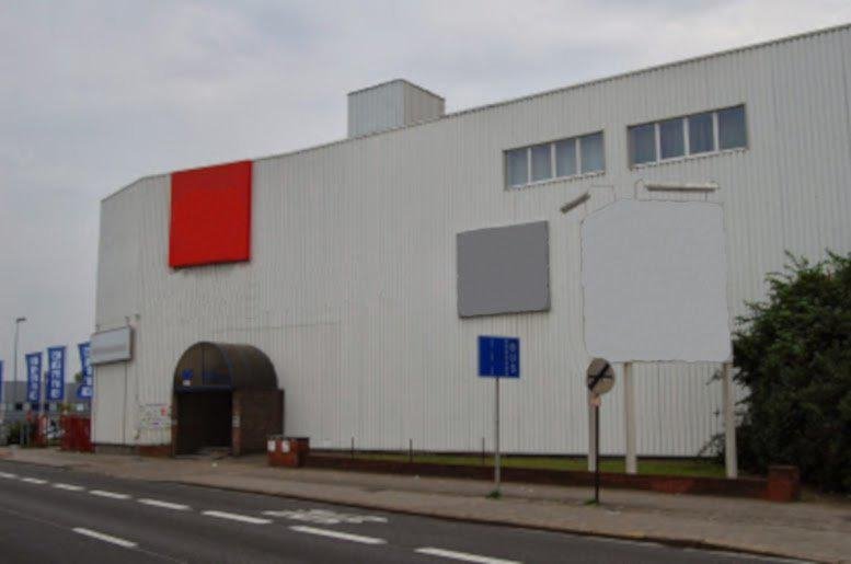 Exterior view of the white commercial building at Boomsesteenweg 690, Antwerp, Belgium.