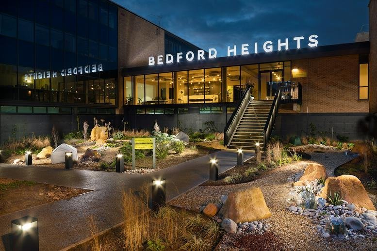 Exterior view of the illuminated entrance and landscaped gardens at Bedford Heights.