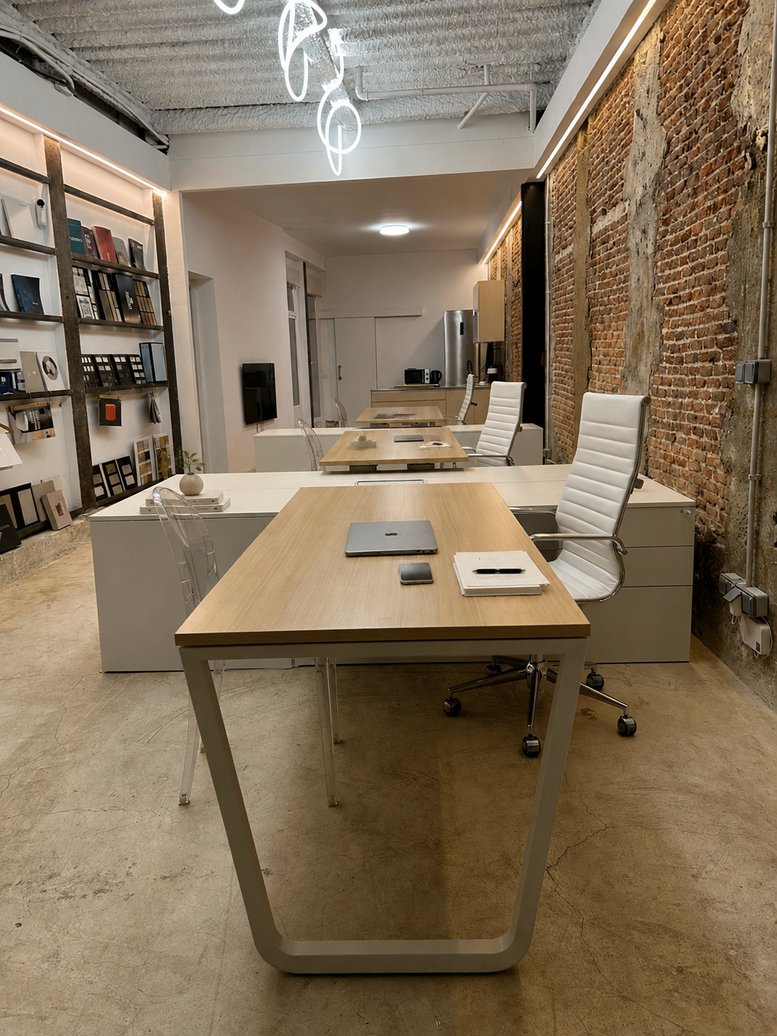 Spacious open-plan workspace at Calle de Quintana, 20,local 5 featuring wooden desks and an exposed brick wall.