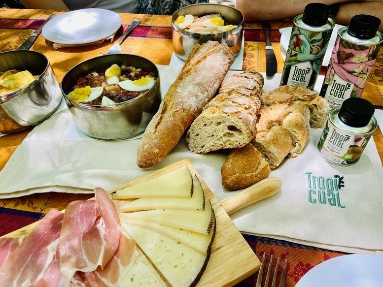 Traditional Spanish breakfast spread with bread, cheese, ham, and olives.