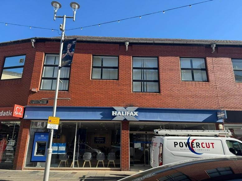 Exterior facade of the brick building on Caroline Street with a bank on the ground floor.