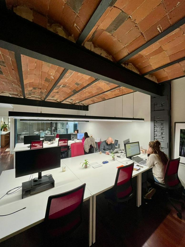 Spacious open-plan workspace at Carrer Ramon Turró i Darder, 7 with vaulted brick ceilings and long desks.
