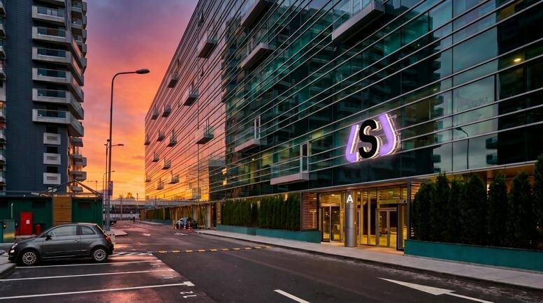 Exterior sunset view of the modern glass facade at Clădirea BOC.