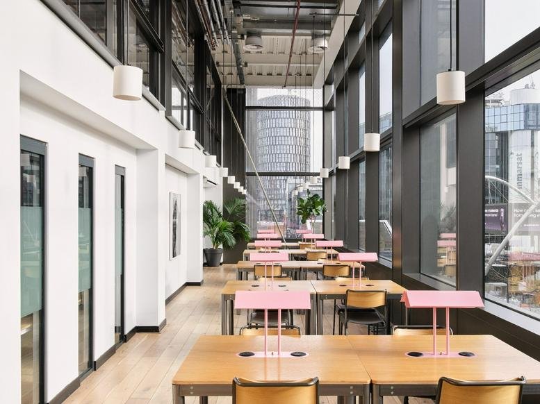Outdoor urban walkway between modern brick and glass office buildings.