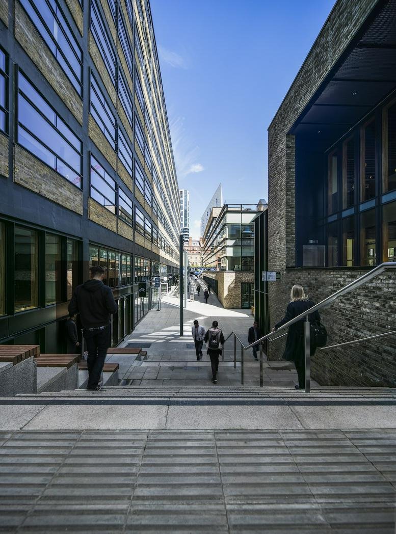 Modern stone stairs leading between office buildings with people walking.