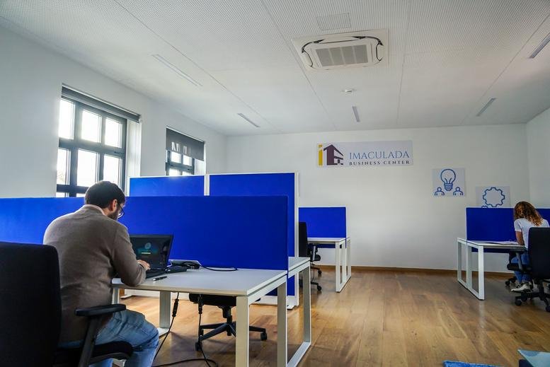 Open-plan workspace with blue privacy screens and desks at 45, Rua do Comércio, Vilar Formoso.