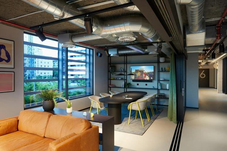 Spacious meeting area at 49 Carrer de Cristóbal de Moura with leather sofa and industrial ceiling.