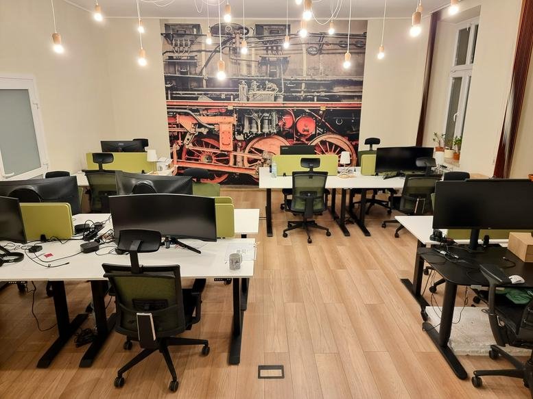 Spacious open-plan workspace at 65A, Królewska, Krowodrza, Krakow with a vintage train engine wall mural.