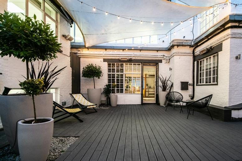 Spacious rooftop terrace with wooden decking and outdoor seating at 66 Old Compton Street, Soho.