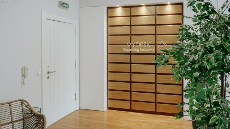 Bright reception area at 98, Rua Doutor Carlos Pires Felgueiras, featuring a wood-paneled feature wall.