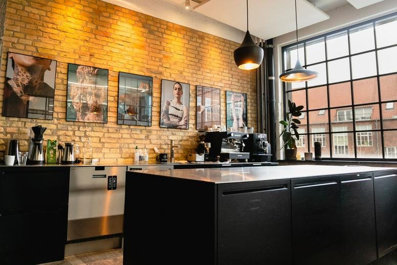 Spacious communal kitchen at Artillerivej 86, 2nd floor with brick walls and modern coffee machines.