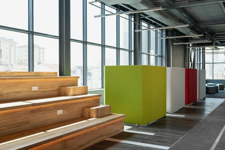 Branded glass wall featuring a basketball player mural and wooden bleacher seating.