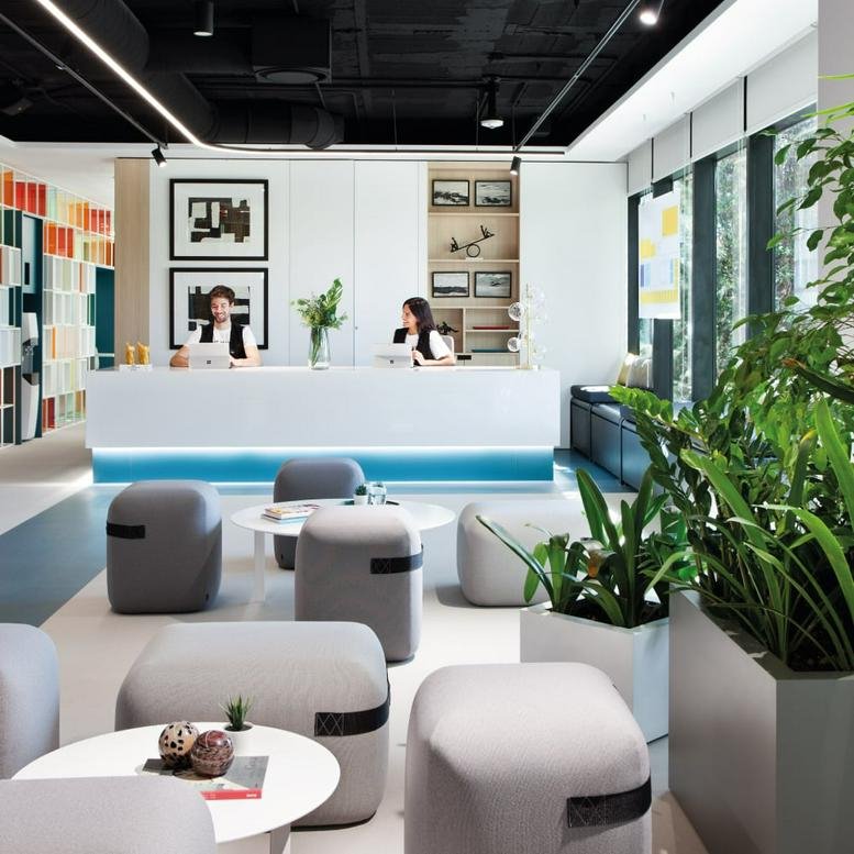 Bright reception area with a long white desk and modern seating at Edificio 3, Planta 2, Avenida de Europa 19.