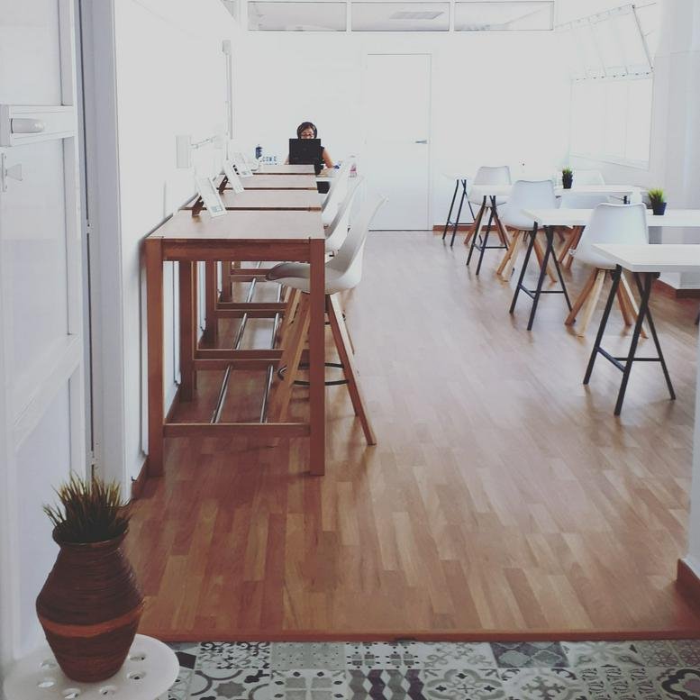 Spacious co-working area with wooden floors and minimalist desks at Avenida Escandinavia 35.