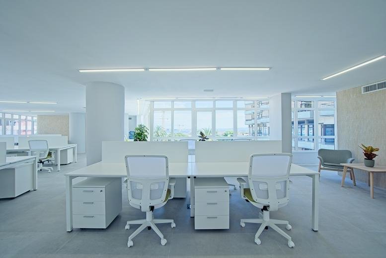 Spacious open-plan workspace at Calle Les Rafaletes 1A, Palma de Mallorca with white desks and natural light.
