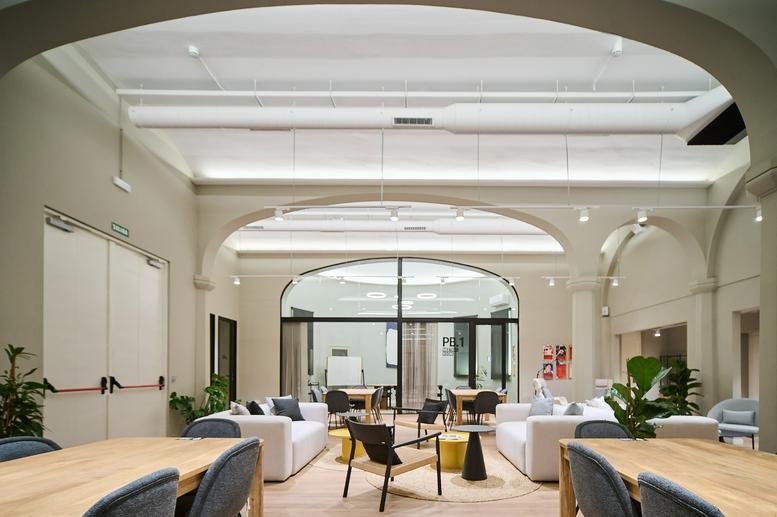 Spacious communal lounge at Carrer De La Tapineria 10 with arched ceilings and natural light.