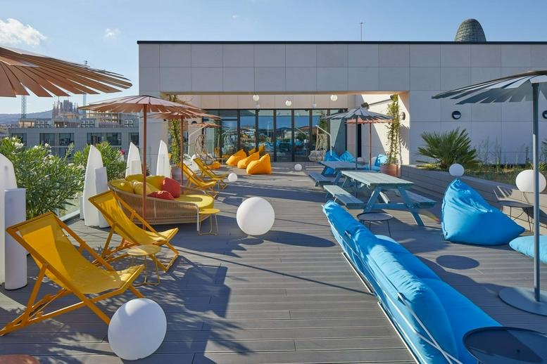 Rooftop terrace at Carrer De Sancho De Ávila, 65, Barcelona with colorful lounge chairs and umbrellas.