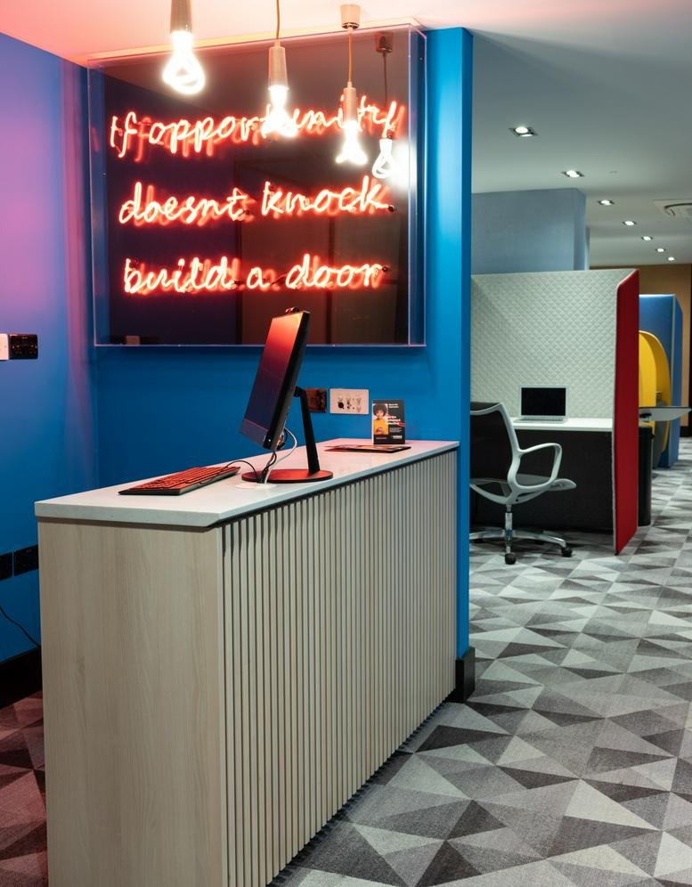 Reception area at Dolomite Avenue, Coventry Business Pk with a wooden desk and neon wall quote.