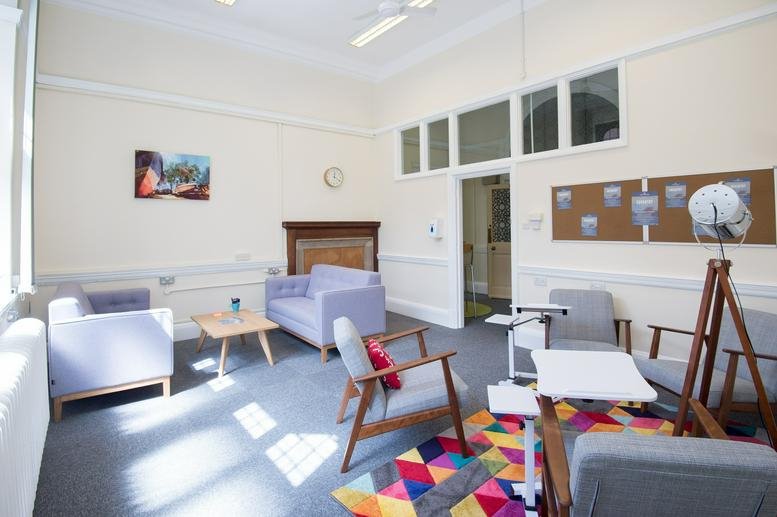 Spacious breakout area at Earl Street, Coventry, West Midlands with sofas, armchairs, and a colourful geometric rug.