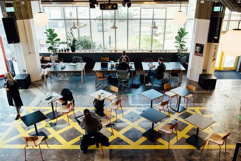 Spacious communal coworking area with diverse seating and large windows at Hove Town Hall.