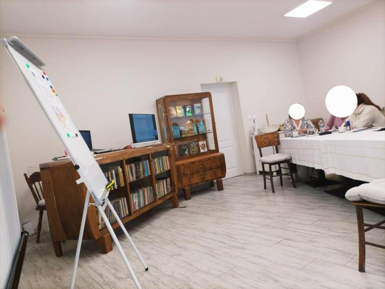 Meeting room at J. Kuri, Varna, Bulgaria with a whiteboard, wooden bookshelves, and a long table.