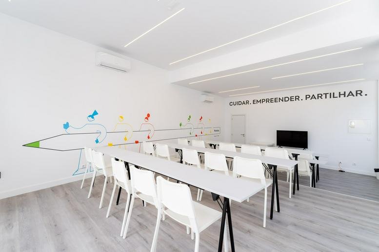Meeting room with long white tables and pencil wall mural at Largo Heróis da Naulila nº 16/17.