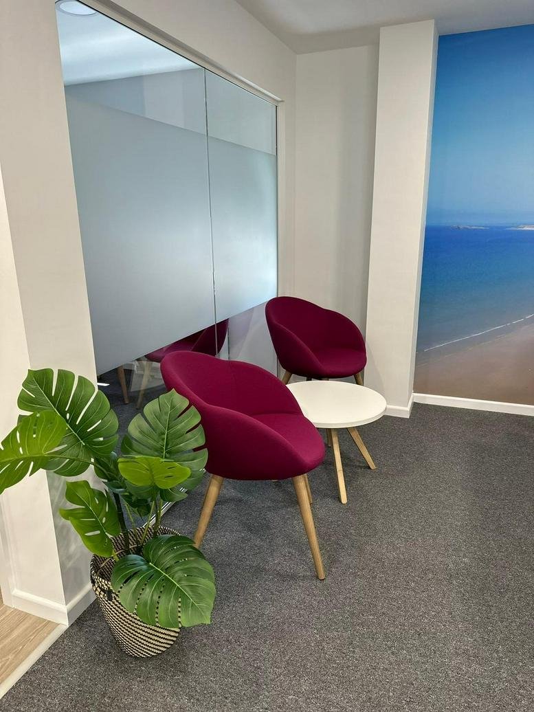 Bright break-out area at Meet Space, 23-24 Park Place with magenta armchairs and a coastal mural.