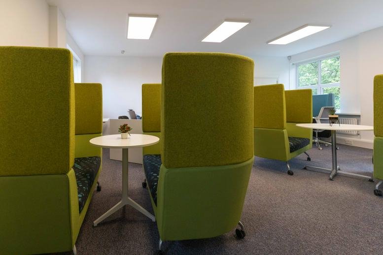 Spacious communal breakout area at Strathallan House featuring vibrant lime green high-back privacy booths.