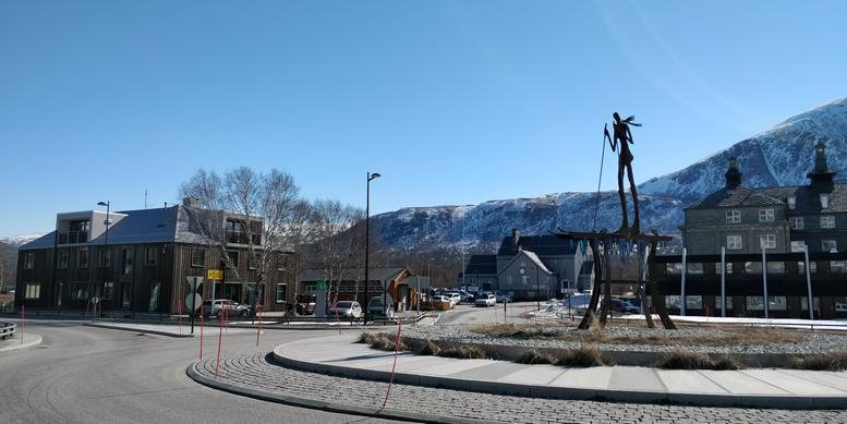 Exterior view of the office building at O. Skasliens veg 1 with a mountain backdrop.