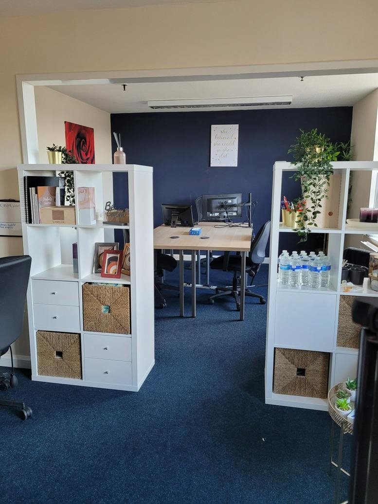Open-plan workspace at Kirkfields Business Centre, Office 5 & 7, with white shelving and a blue feature wall.