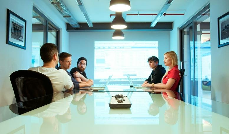 Professional meeting in progress around a sleek white table at Ohlauer Strasse 43, Berlin.