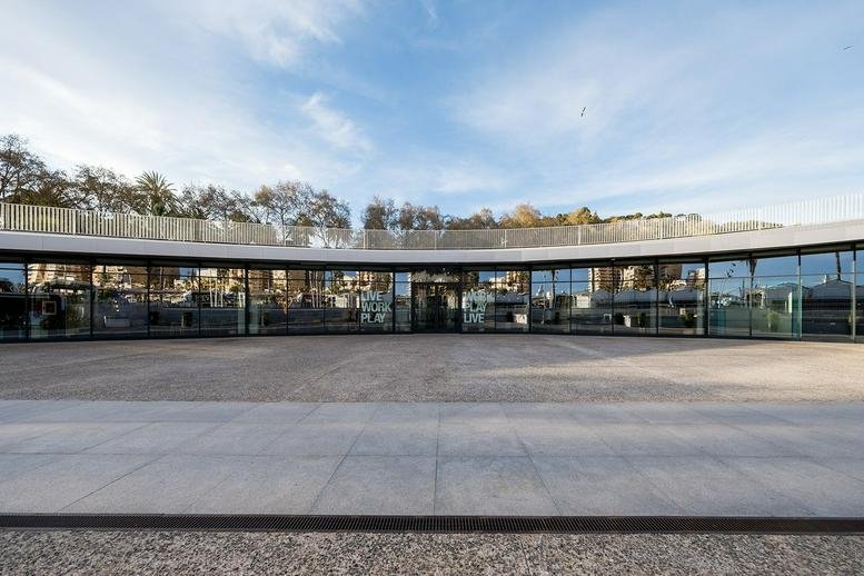 Exterior view of the curved glass facade at Paseo del Muelle Uno, Sin Numero, Málaga.