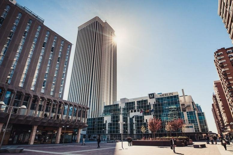 Exterior view of the iconic white skyscraper Torre Picasso under a bright sun.