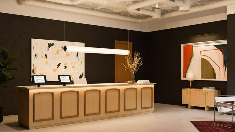 Sleek wood-paneled reception desk at Rua Alexandre Herculano 50 with abstract art and warm pendant lighting.