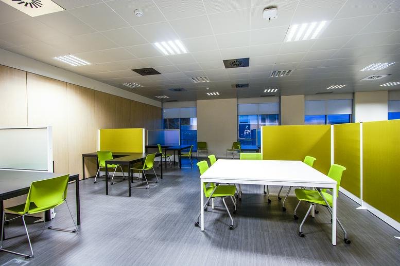 Spacious open-plan office at Rua da Tecnologia K, Épsilon, Lagoa with lime green chairs and white tables.