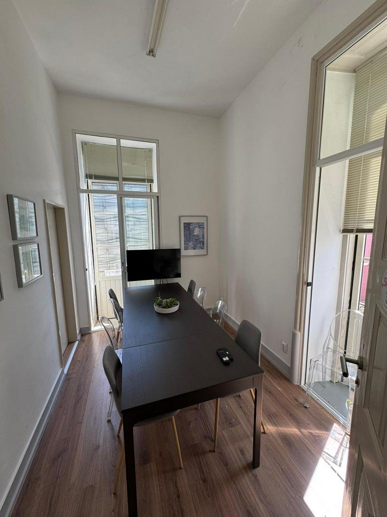 Meeting room at Rua Doutor Calado 26 with dark wood table and natural light.