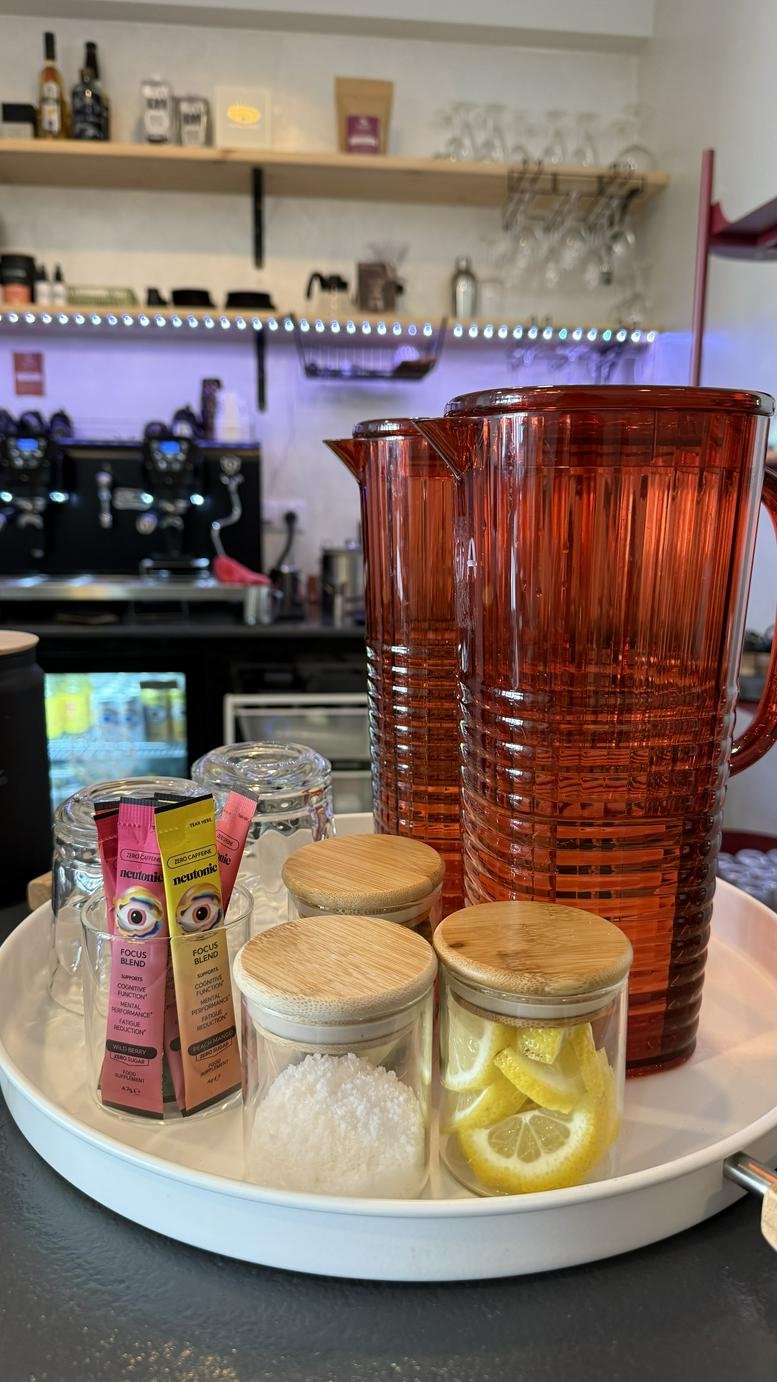 Self-service water station with citrus slices and tea packets.