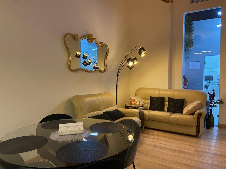 Spacious communal lounge at Rua Samuel Gonçalves Sanches 19A with leather sofas and a glass dining table.