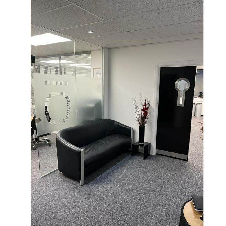 Reception area at Sandridge Park, Oak Court Business Centre with a black leather sofa and frosted glass partition.