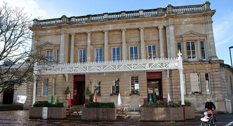 Grand stone facade of South Vaults, Green Park Station featuring classic columns and a decorative white iron veranda.