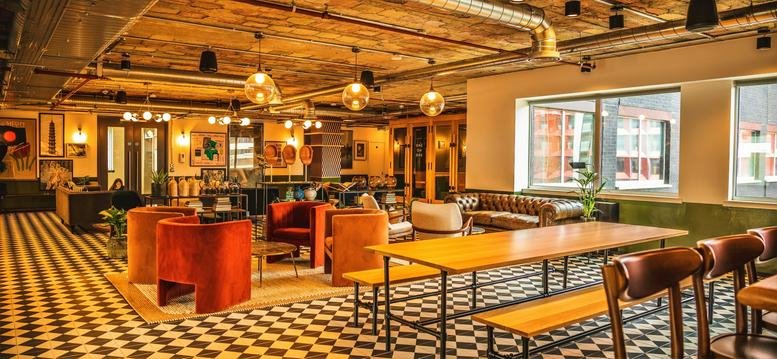 Spacious communal lounge at 1 Butterwick with colourful velvet seating and patterned tile floors.