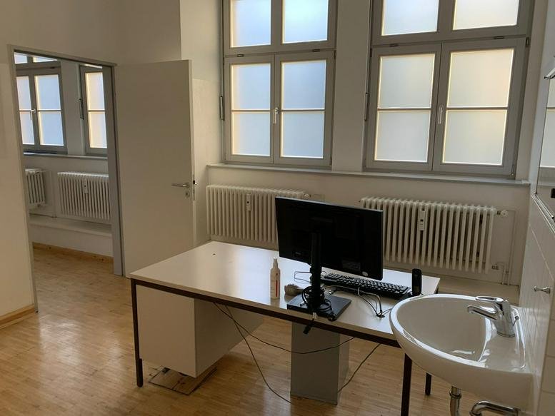Bright workspace at 11 Liebenwalder Straße, Ground Floor, Wedding, Berlin with a desk, monitor, and large windows.