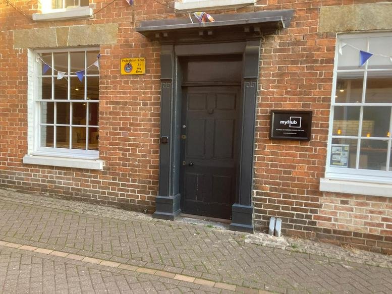 Exterior brick facade and black entrance door of myHub Banbury, 13 Butchers Row.