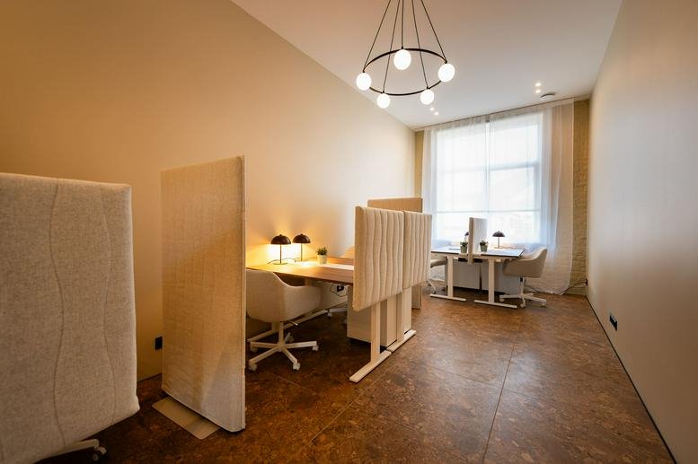 Wide view of the 130K9 Krišjāņa Barona iela coworking space with acoustic partitions and a chandelier.